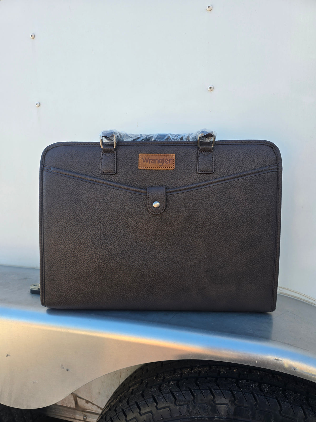 Front of Brown Wrangler PU Leather Laptop bag with exterior pockets, luggage strap, interior pockets, shoulder strap and carrying handle