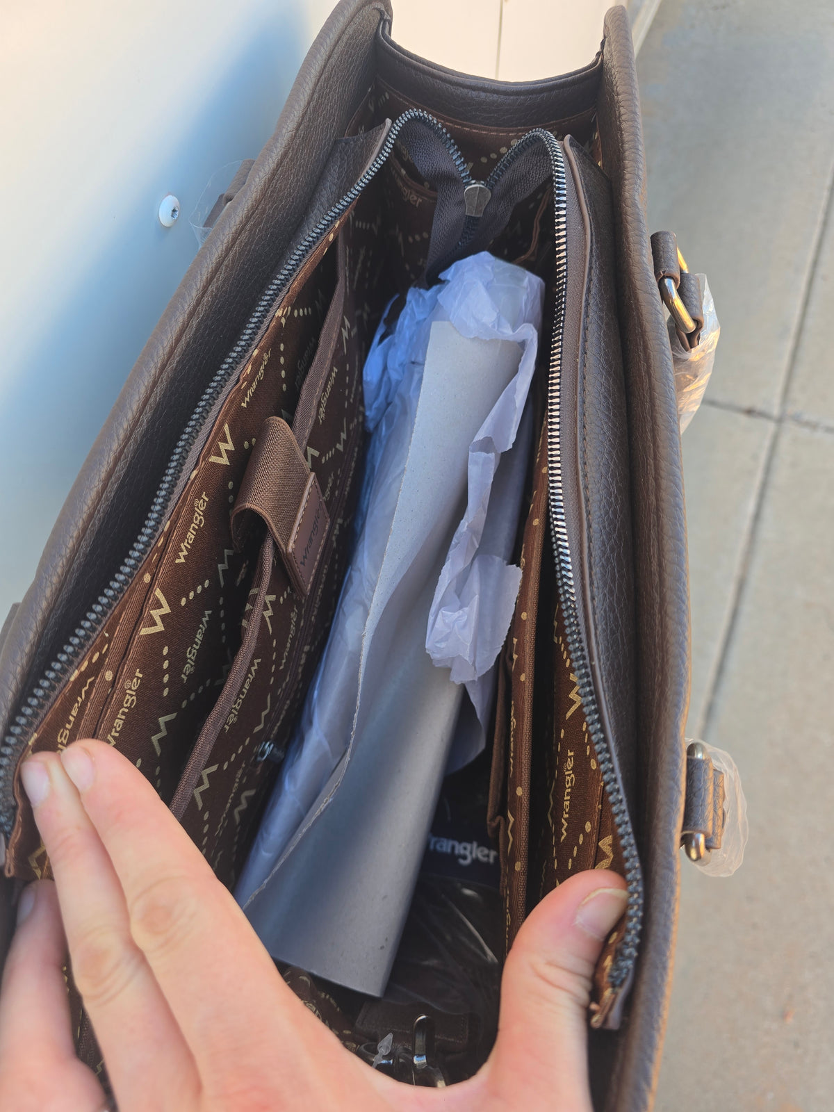 Inside of Brown Wrangler PU Leather Laptop bag with exterior pockets, luggage strap, interior pockets, shoulder strap and carrying handle